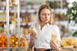 © JackF - Young woman buyer chooses mayonnaise sauce in grocery store