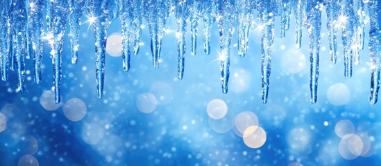 Wall Mural - icicles hanging from above with a blurred blue background and bokeh effect creating a winter atmosph