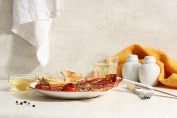 Wall Mural - Fried bacon with toasts and dried tomatoes on plate on table against white background