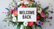 © Erlinda - welcome back lettering on plain white card on bouquet of flowers background