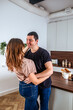 © Maryna - Couple celebrating love in a cozy kitchen on Valentine's Day with laughter and affection
