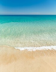 Wall Mural - Soft waves caress the sandy shore under a vibrant blue sky. Serenity at its finest!