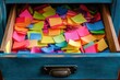 © Russi - An open drawer full of brightly colored sticky notes of various sizes, representing organization and creativity in schoolwork