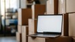 © Lexyat - Laptop on Cardboard Boxes in Warehouse: E-commerce and Logistics
