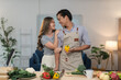 © crizzystudio - Happy asian couple preparing fresh ingredients for a nutritious meal in a modern kitchen, enjoying quality time together while embracing a vibrant and healthy lifestyle