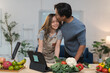 © crizzystudio - Young asian couple kissing while preparing healthy meal together with online recipe on tablet in modern kitchen, enjoying romantic leisure time at home