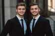 © N. W. - photo of two young business men in suits smiling into the camera at work in the office in finance.