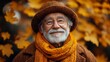 © Atchariya63 - Smiling elderly man in a cozy scarf surrounded by autumn leaves.