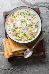 Wall Mural - Chicken Pot Pie Soup with tender chicken, veggies, and a creamy broth closeup on the plate on the table. Vertical top view from above