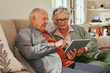 © Rido - Old couple using digital tablet at home together