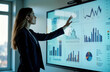 © Pete - Businesswoman presents data-driven e-commerce strategy. Points to charts, graphs on large interactive display in meeting room. Display shows various metrics, trends. Pro, confident atmosphere.
