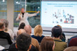 © Anton Gvozdikov - Corporate seminar session with a presenter addressing an engaged audience in a modern venue. Attendees focused on the speaker delivering a presentation.