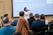 © Anton Gvozdikov - Focused audience watches speaker during professional conference presentation in modern meeting room.