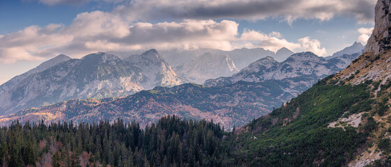 Wall Mural - Stunning landscape of Durmitor National Park with mountain peaks, pine forest and clouds in Montenegro