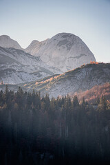 Wall Mural - Stunning sunrise illuminates the peaks of the Durmitor massif, casting long shadows on the dense coniferous forest below