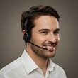 © 령표 김 - En manlig anställd som bär ett headset ler lätt.