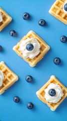 Wall Mural - Belgian waffles with blueberries and whipped cream on blue background.