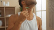 © Krakenimages.com - Hispanic man in a spa using a jade roller on his neck in a serene beauty center room, enhancing his wellness and skincare routine with appealing attractiveness.