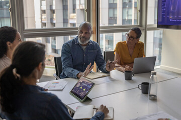 Mature African American businessman leading a business meeting in a conference room