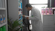 © Krakenimages.com - Young man searching shelves in pharmacy showing determination and focus