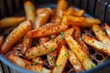 © juliars - Close up of delicious potato wedges cooking in an air fryer seasoned with herbs and spices