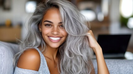 a stunning woman with long silver hair poses happily in a casual setting, exuding beauty and confide