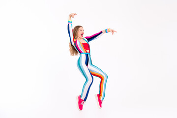 Young woman wearing a trendy, colorful striped outfit, dancing joyfully on a white background.