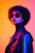 © Sergey - A stylish individual with an afro hairstyle wears sunglasses and a leather jacket against a vibrant gradient background.