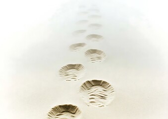 Canvas Print - Footprints disappearing into hazy white sand.