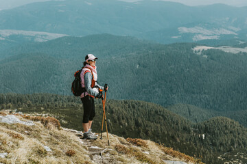 senior woman hiking in the summer mountain