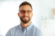 © Kateryna - Close-up photo of a successful attractive caucasian or arabian businessman with glasses, stand confidently in modern office, showcasing positivity and readiness for new challenges, smiles at camera