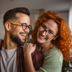 Portrait of adult hugged couple smile at home happy together