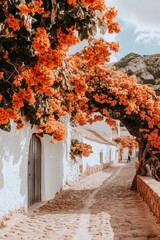 Wall Mural - A picturesque cobblestone pathway lined with vibrant orange bougainvillea flowers, leading to a charming white building.