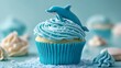 © saima - A cupcake with frosting that mimics a rippling ocean wave and an edible sugar dolphin