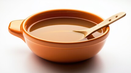 Wall Mural - Ceramic bowl filled with liquid and wooden spoon on white background with copy space