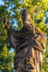 Wall Mural - Religious statue of Augustine of Hippo mounted to the balustrade of Charles Bridge in Prague, Czech Republic