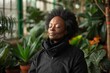 © Vera - Meditating Black Woman Surrounded by Lush House Plants in Home, Exuding Calm and Zen Vibes