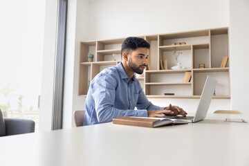 serious arabian office employee working on project at desk, correspond to client, typing e-mail, ana