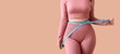 © Pixel-Shot - Young sporty woman measuring her waist on beige background with space for text. Weight loss concept