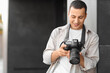 © Pixel-Shot - Male photographer with modern camera outdoors