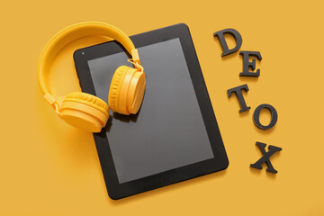 Canvas Print - Modern tablet computer, headphones and word DETOX on yellow background