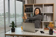 © kamiphotos - woman stretching and working at home, beautiful woman relax at desk, stretching and resting in home office, calm and profile of worker for self care, businesswoman stretching arms overhead