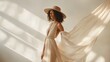 © Chayanin Wongpracha - elegant woman in beige dress and hat with flowing fabric