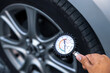© Eakrin - Hand car mechanic holding car tire pressure check equipment tool to checking low tire pressure inflating tires to or refill or air inflate to safety and car care service maintenance inspection.