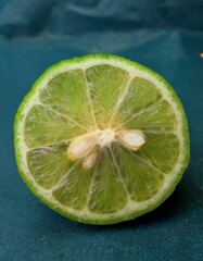 Wall Mural - Close-up of a juicy lime cut in half, revealing its vibrant green flesh and seeds.