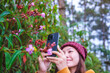 © Farknot Architect - A woman taking photos of wild flowers with smartphone in the forest
