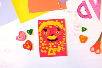 Child making homemade greeting card from paper. Gift for Mothers day, Fathers day, Birthday or Valentines day.  Kid craft. Home Education game. development concept