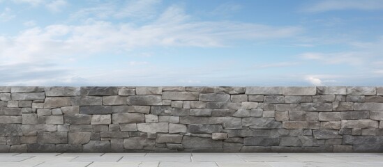 Poster - Gray stone wall with a clear blue sky in the background, showcasing a horizon line that adds depth to the rustic textured surface.