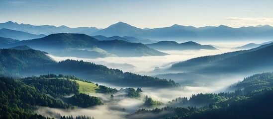 Poster - Mountain landscape with rolling hills and mist at sunrise; soft blue and green tones; layered mountains and valleys create depth and tranquility.
