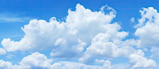Poster - Clear blue sky with fluffy white clouds creating a serene summer atmosphere, featuring vibrant blues and soft whites prominently positioned.